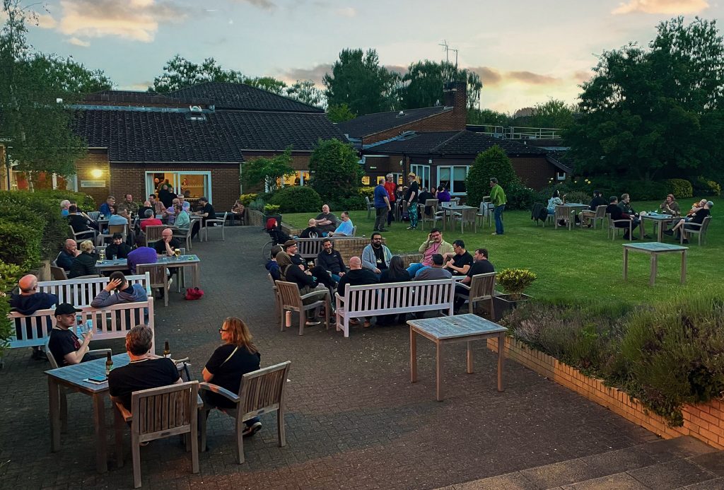People enjoy a drink outside a a conference venue in Summer
